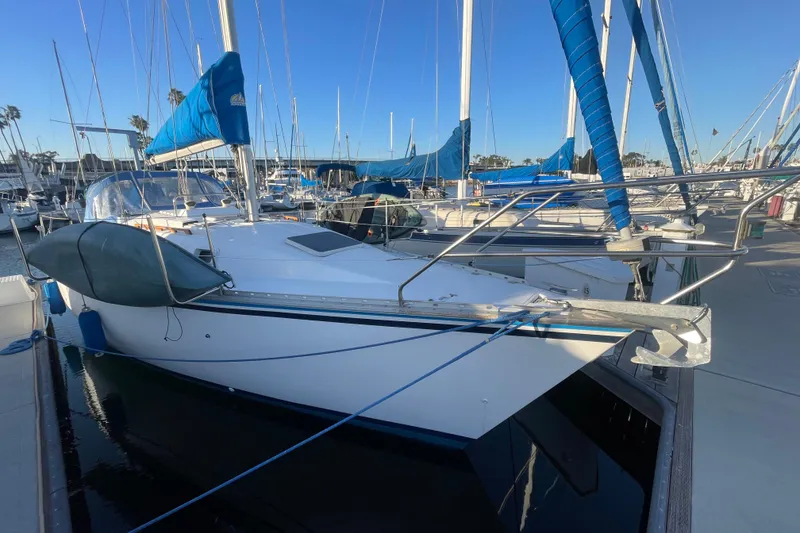 The Image of 1987 Beneteau 31 sailboat docked in marina, featuring blue sails and clear sky. - 0