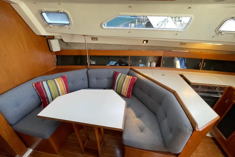 Slide: The Image of Cozy interior of 1987 Beneteau 31 sailboat with cushioned seating and dining area. - 11