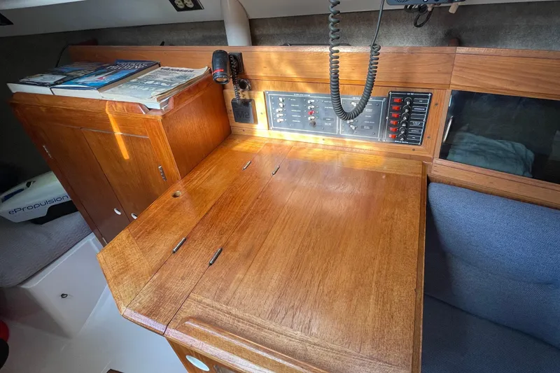 Slide: The Image of Interior of 1987 Beneteau 31 sailboat with wooden navigation station and control panel. - 12