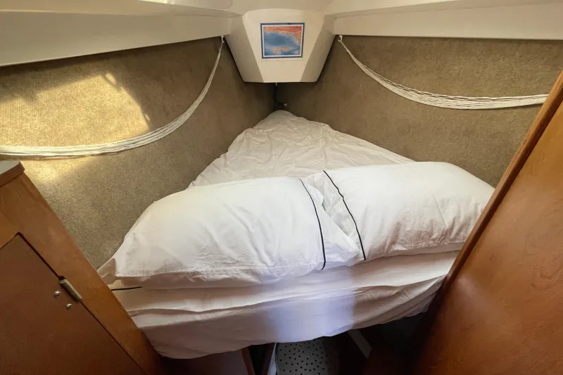 Slide: The Image of Cozy cabin interior of 1987 Beneteau 31 sailboat with neatly made bed. - 14