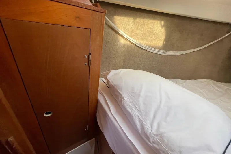 Slide: The Image of Cozy cabin interior of 1987 Beneteau 31 sailboat with wooden cabinet and bed. - 15