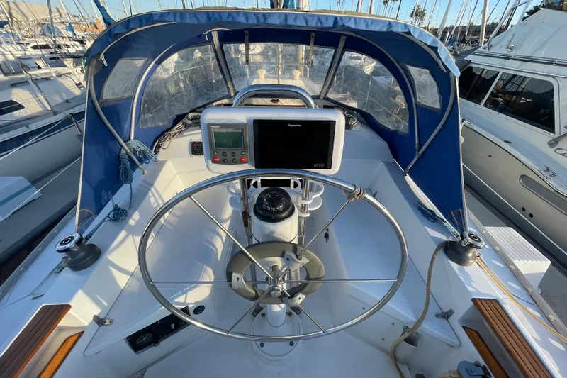 Slide: The Image of Cockpit of 1987 Beneteau 31 sailboat with steering wheel and navigation equipment. - 3