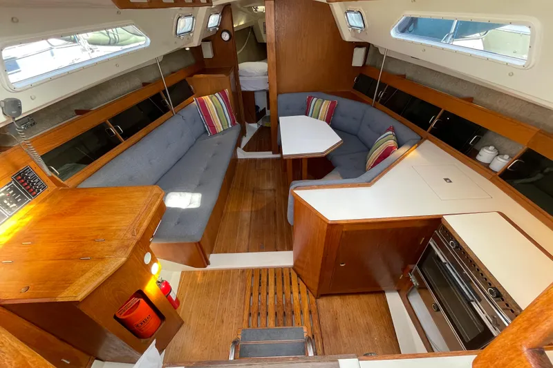 Slide: The Image of Interior of a 1987 Beneteau 31 sailboat with cozy seating and wooden finishes. - 8