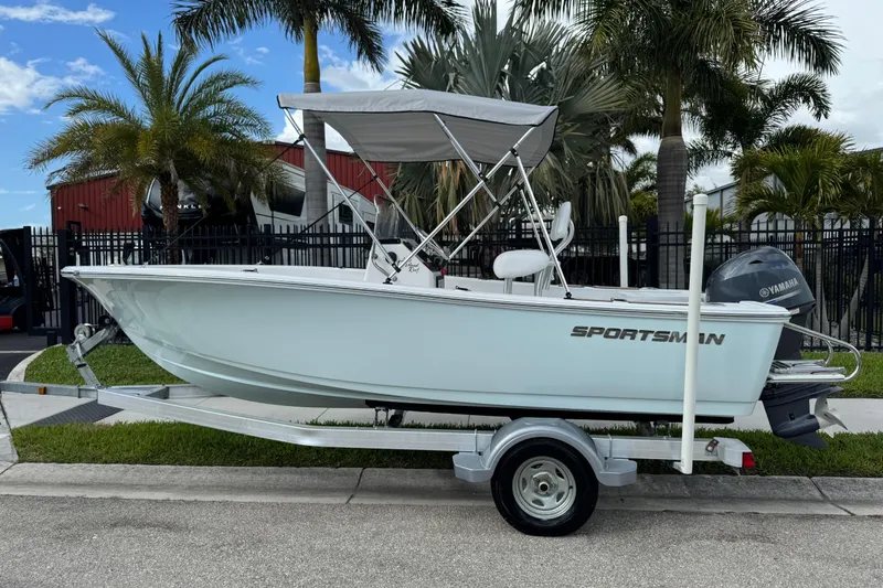 Slide: The Image of 2016 Sportsman Island Reef 17 Center Console boat on trailer, surrounded by palm trees. - 1