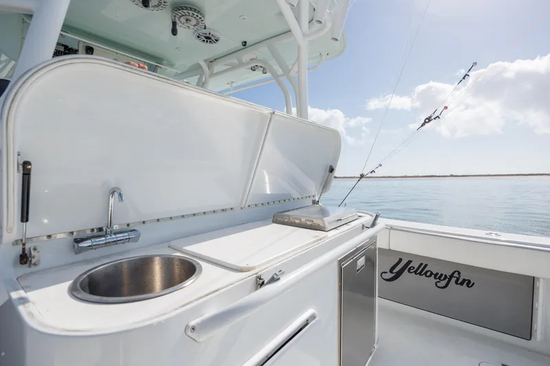 Slide: The Image of 2014 Yellowfin 42 Offshore boat with sink and storage, set against a serene ocean backdrop. - 21