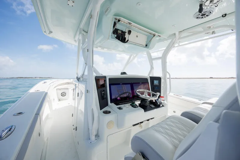 Slide: The Image of 2014 Yellowfin 42 Offshore boat cockpit with modern navigation equipment on calm waters. - 23