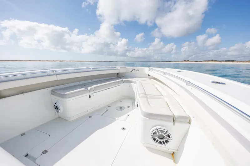 Slide: The Image of 2014 Yellowfin 42 Offshore boat interior with seating, under a bright blue sky. - 29