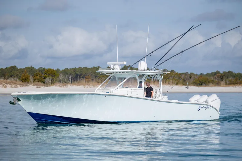 Slide: The Image of 2014 Yellowfin 42 Offshore boat on calm water, with fishing rods and outboard motors. - 3