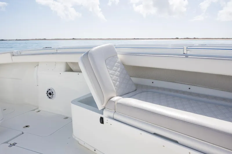 Slide: The Image of 2014 Yellowfin 42 Offshore boat interior with white cushioned seating and ocean view. - 33