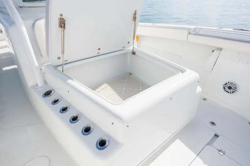 Slide: The Image of Open storage compartment on 2014 Yellowfin 42 Offshore boat, featuring rod holders and speaker. - 35