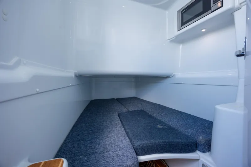 Slide: The Image of 2014 Yellowfin 42 Offshore cabin interior with bed and microwave, showcasing sleek design. - 38