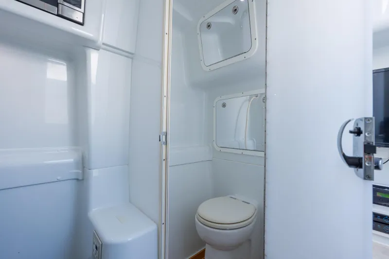 Slide: The Image of 2014 Yellowfin 42 Offshore boat bathroom with white interior and compact design. - 41