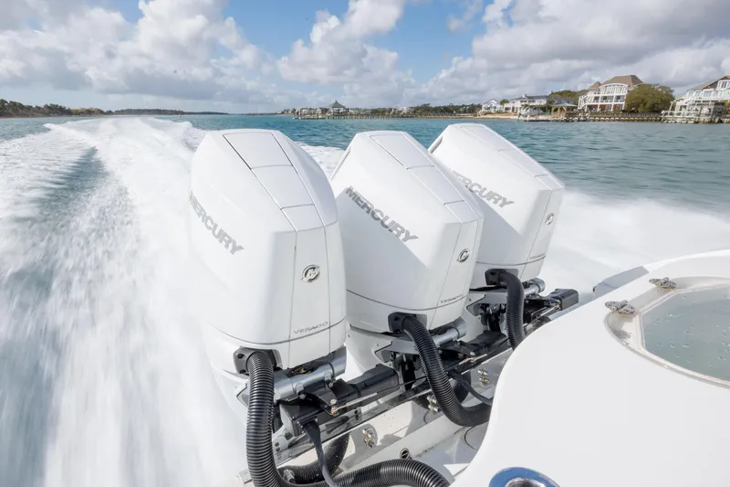 Slide: The Image of 2014 Yellowfin 42 Offshore boat with triple Mercury engines cruising on water. - 42