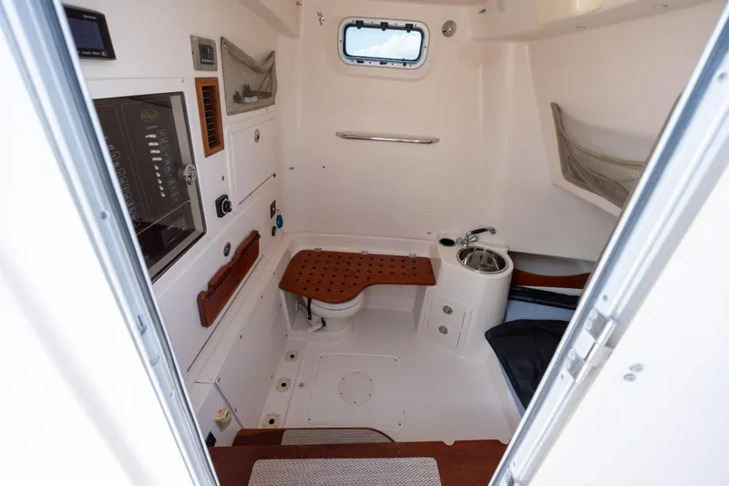 Slide: The Image of 2013 Grady-White Canyon 306 boat interior with compact bathroom and sink. - 10