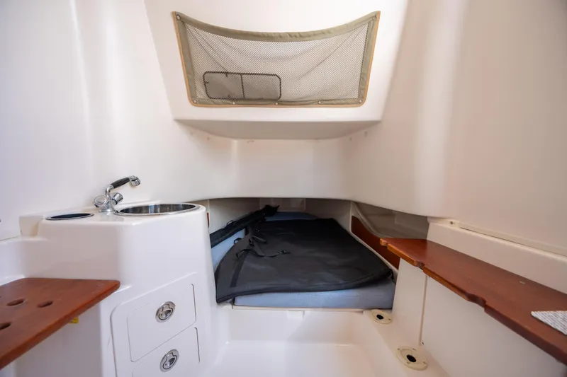 Slide: The Image of 2013 Grady-White Canyon 306 cabin interior with sink, storage, and seating area. - 14