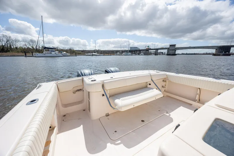 Slide: The Image of 2013 Grady-White Canyon 306 boat on calm water near a bridge and marina. - 15