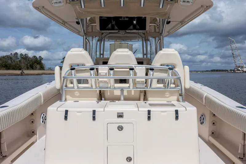 Slide: The Image of 2013 Grady-White Canyon 306 boat interior with seating and rod holders on a calm waterway. - 19