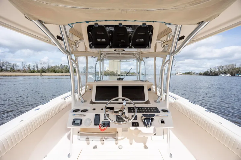 Slide: The Image of 2013 Grady-White Canyon 306 boat interior with steering console on a calm river. - 21