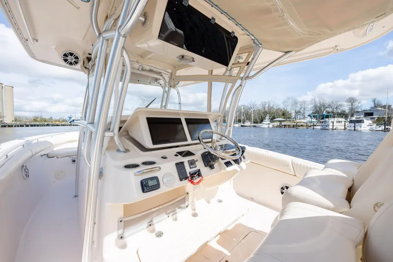 Slide: The Image of 2013 Grady-White Canyon 306 boat interior with helm, steering wheel, and navigation screens. - 23