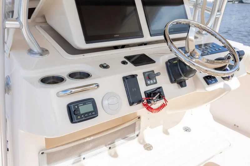 Slide: The Image of 2013 Grady-White Canyon 306 helm with steering wheel, electronics, and controls. - 24