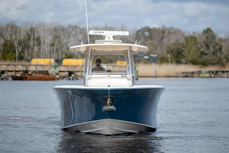 Slide: The Image of 2013 Grady-White Canyon 306 boat on calm water, front view, with trees in background. - 33