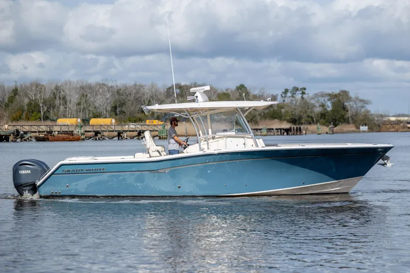 Slide: The Image of 2013 Grady-White Canyon 306 boat on water, featuring Yamaha engines, under cloudy sky. - 4