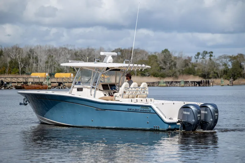 Slide: The Image of 2013 Grady-White Canyon 306 boat with dual Yamaha engines on a calm waterway. - 7