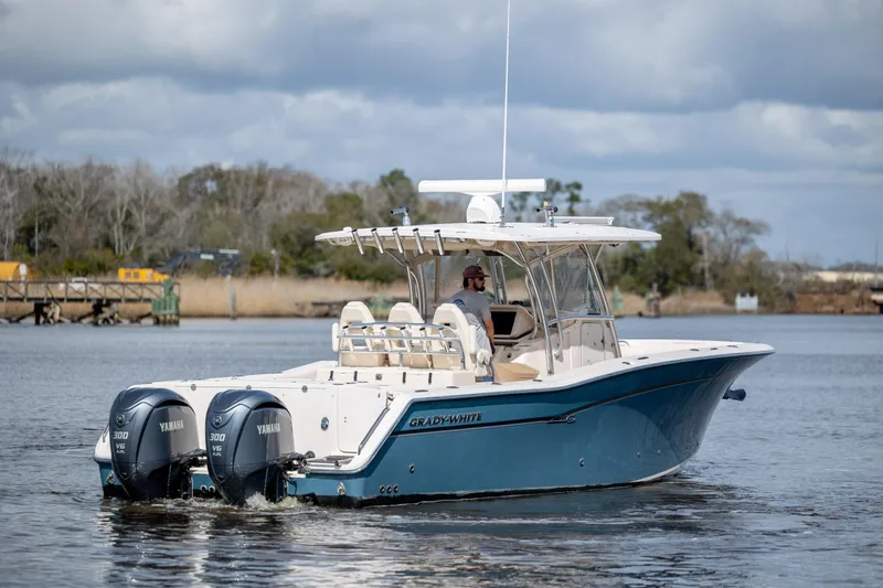 Slide: The Image of 2013 Grady-White Canyon 306 boat with dual Yamaha engines on a calm waterway. - 9