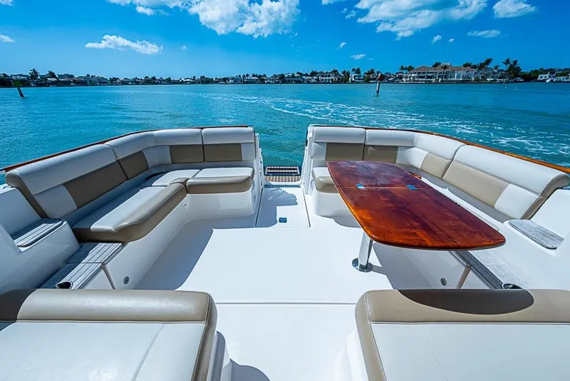 Slide: The Image of Luxurious 2012 Tiara Yachts 3100 Coronet with spacious seating and wooden table on open water. - 13