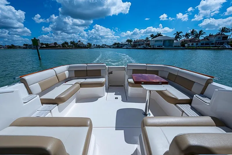 Slide: The Image of 2012 Tiara Yachts 3100 Coronet boat interior with seating, table, and scenic water view. - 16