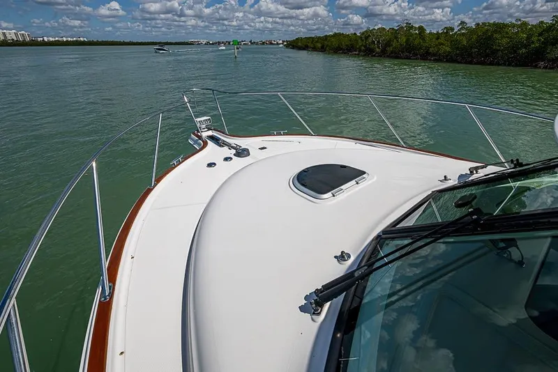 Slide: The Image of 2012 Tiara Yachts 3100 Coronet cruising on a scenic waterway under a partly cloudy sky. - 17