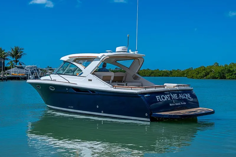 Slide: The Image of 2012 Tiara Yachts 3100 Coronet boat on serene water, clear blue sky background. - 2