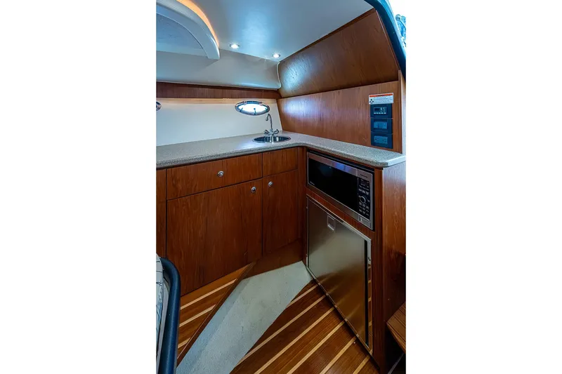 Slide: The Image of 2012 Tiara Yachts 3100 Coronet interior kitchen with wood cabinetry and modern appliances. - 22