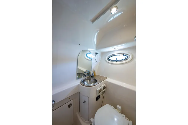 Slide: The Image of Compact bathroom in 2012 Tiara Yachts 3100 Coronet with sink, mirror, and porthole. - 24