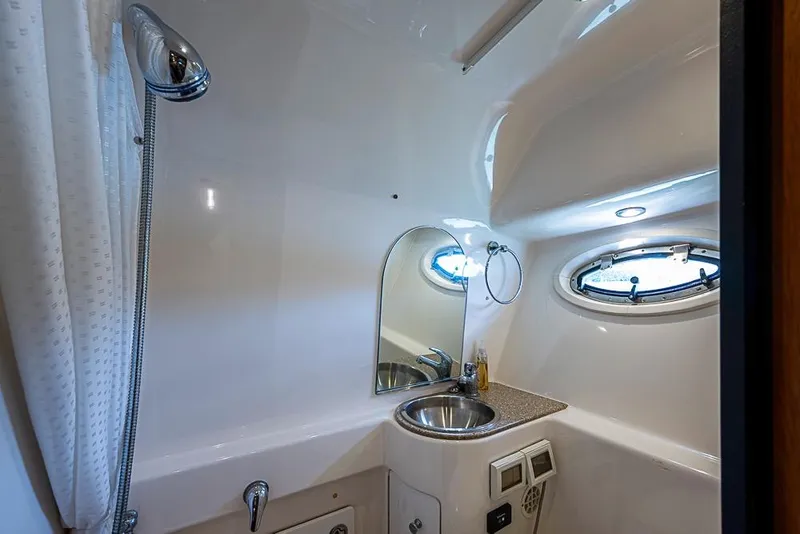 Slide: The Image of 2012 Tiara Yachts 3100 Coronet bathroom with sink, mirror, and porthole window. - 25