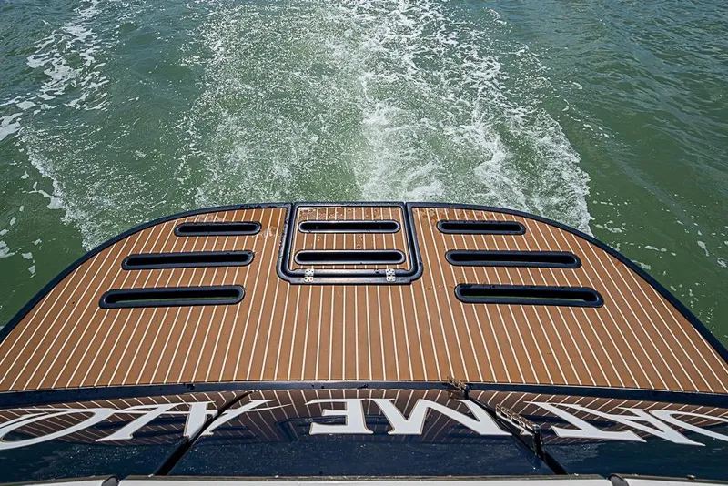 Slide: The Image of 2012 Tiara Yachts 3100 Coronet cruising, showcasing elegant teak deck and wake trail. - 27
