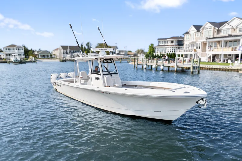 The Image of 2024 Regulator 34 boat cruising in a scenic waterfront neighborhood. - 0