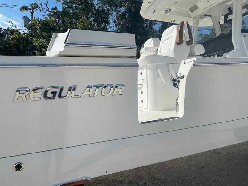 Slide: The Image of 2024 Regulator 34 boat interior with luxurious seating and sleek design by the water. - 10