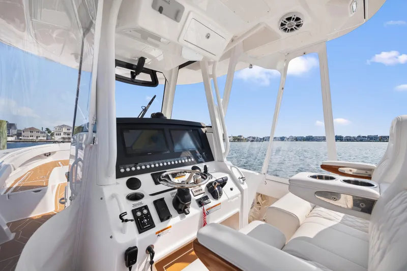 Slide: The Image of 2024 Regulator 34 boat interior with modern helm and seating, overlooking calm waters. - 3