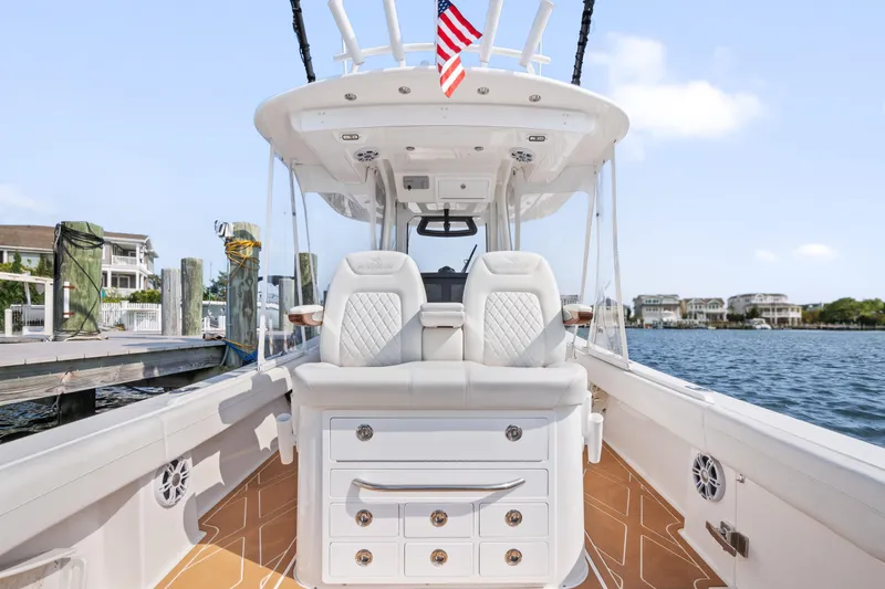 Slide: The Image of 2024 Regulator 34 boat interior with luxurious seating and storage, docked by waterfront homes. - 4