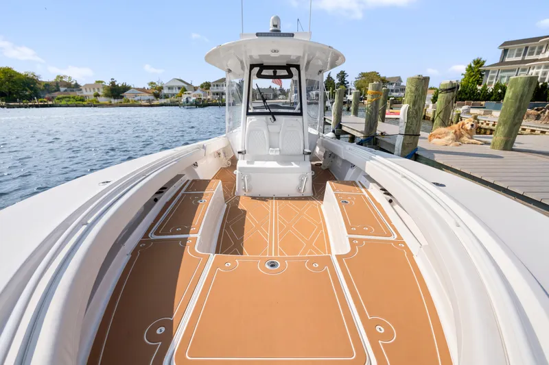 Slide: The Image of 2024 Regulator 34 boat docked, featuring spacious deck and modern design. - 5