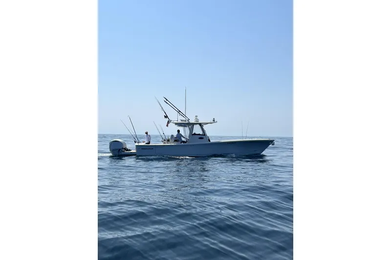 Slide: The Image of 2024 Regulator 34 boat on calm ocean waters, equipped for fishing. - 9