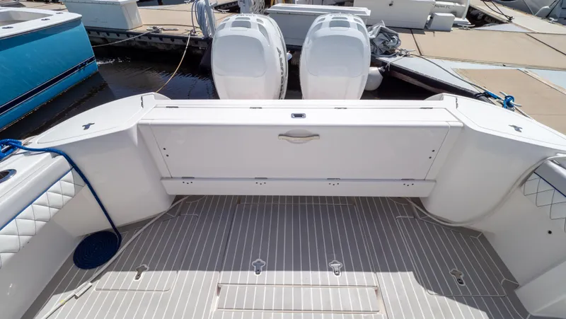 Slide: The Image of 2022 Intrepid 345 Valor boat deck with twin engines, docked at marina. - 49