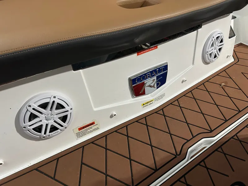 Slide: The Image of 2024 Cobalt R6 boat with speakers and brown flooring. - 34