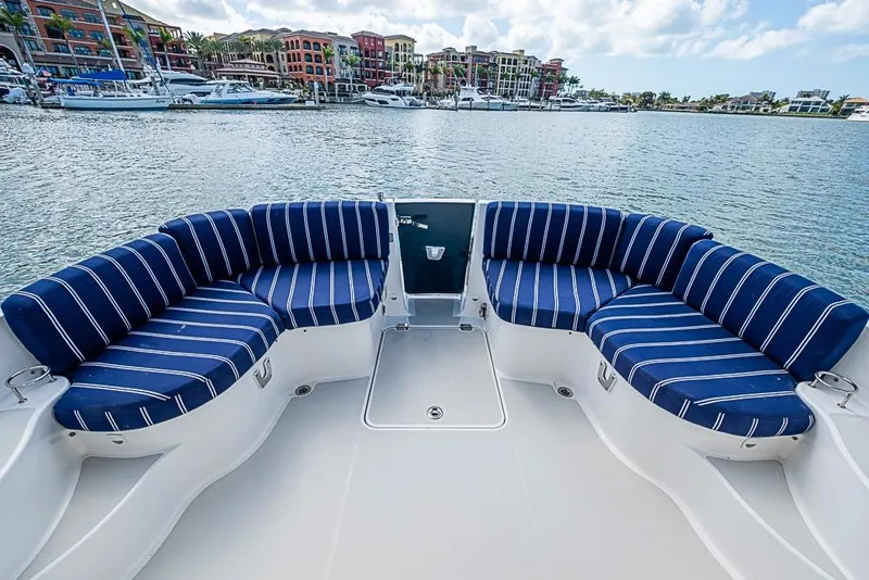 Slide: The Image of 2011 Back Cove 30 boat with striped seating, docked in a scenic marina. - 13