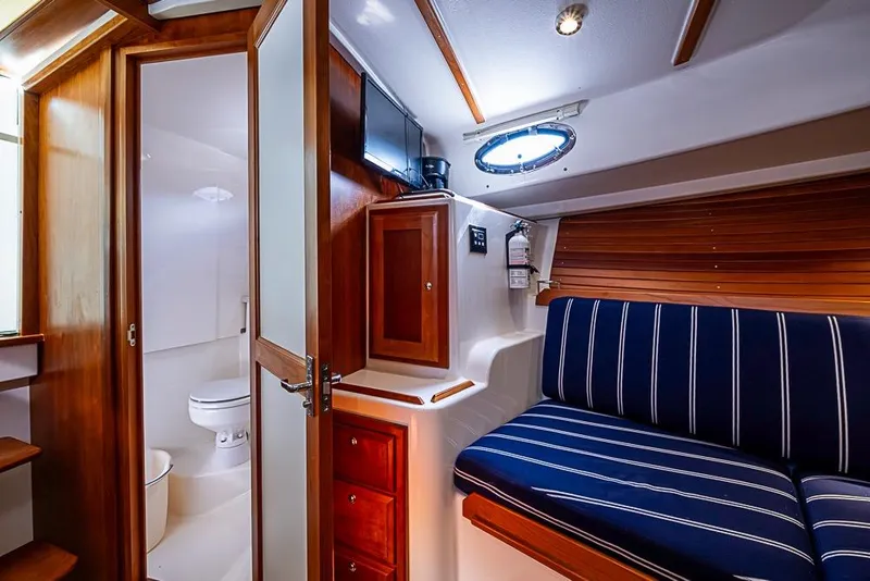 Slide: The Image of Interior of 2011 Back Cove 30 boat with striped seating and wooden cabinetry. - 18