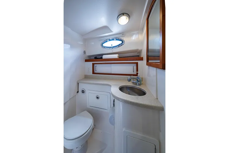 Slide: The Image of 2011 Back Cove 30 yacht bathroom with sink, toilet, and porthole window. - 21