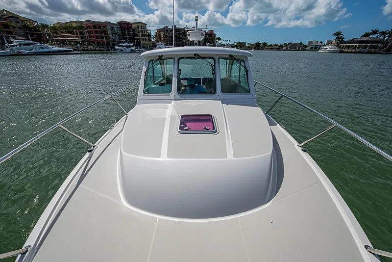 Slide: The Image of 2011 Back Cove 30 boat on calm water with scenic marina backdrop. - 26