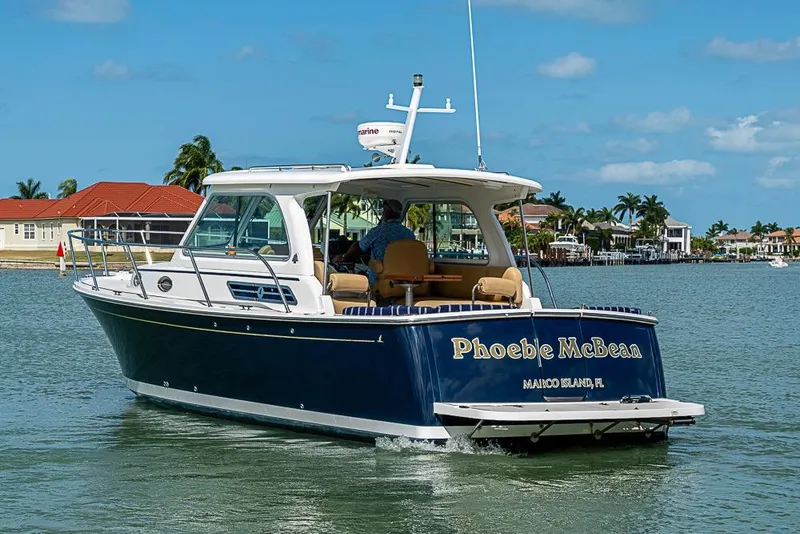 Slide: The Image of 2011 Back Cove 30 boat cruising near Marco Island, Florida, with clear skies and waterfront homes. - 3