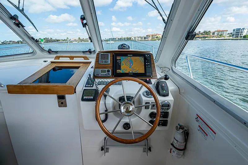 Slide: The Image of 2011 Back Cove 30 boat helm with navigation equipment and steering wheel on open water. - 6
